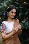 Woman in traditional attire with jewelry against a green leafy background