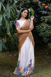 Woman in a traditional saree with floral patterns standing in a garden.