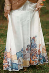 White skirt with colorful animal prints worn by a person outdoors.
