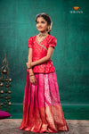 Young girl in a red and pink traditional outfit against a teal background