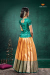 Woman wearing a green blouse and orange skirt with a dark green background