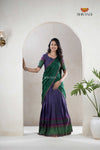 Woman wearing a green and purple saree with 'Shivangi' branding, standing in front of a mirror.
