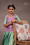 Young girl in a traditional outfit with a floral pillow on a chair