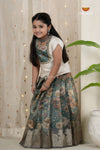 Young girl in a floral dress standing in front of a curtain with decorative lights