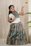 Young girl in traditional outfit with floral design against a light curtain background